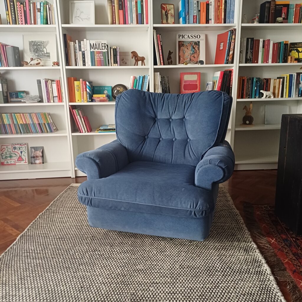 Una sala tranquila con un sillón y estanterías
